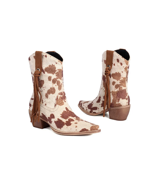 Cowboy boots with brown and white cow print pattern on a white background