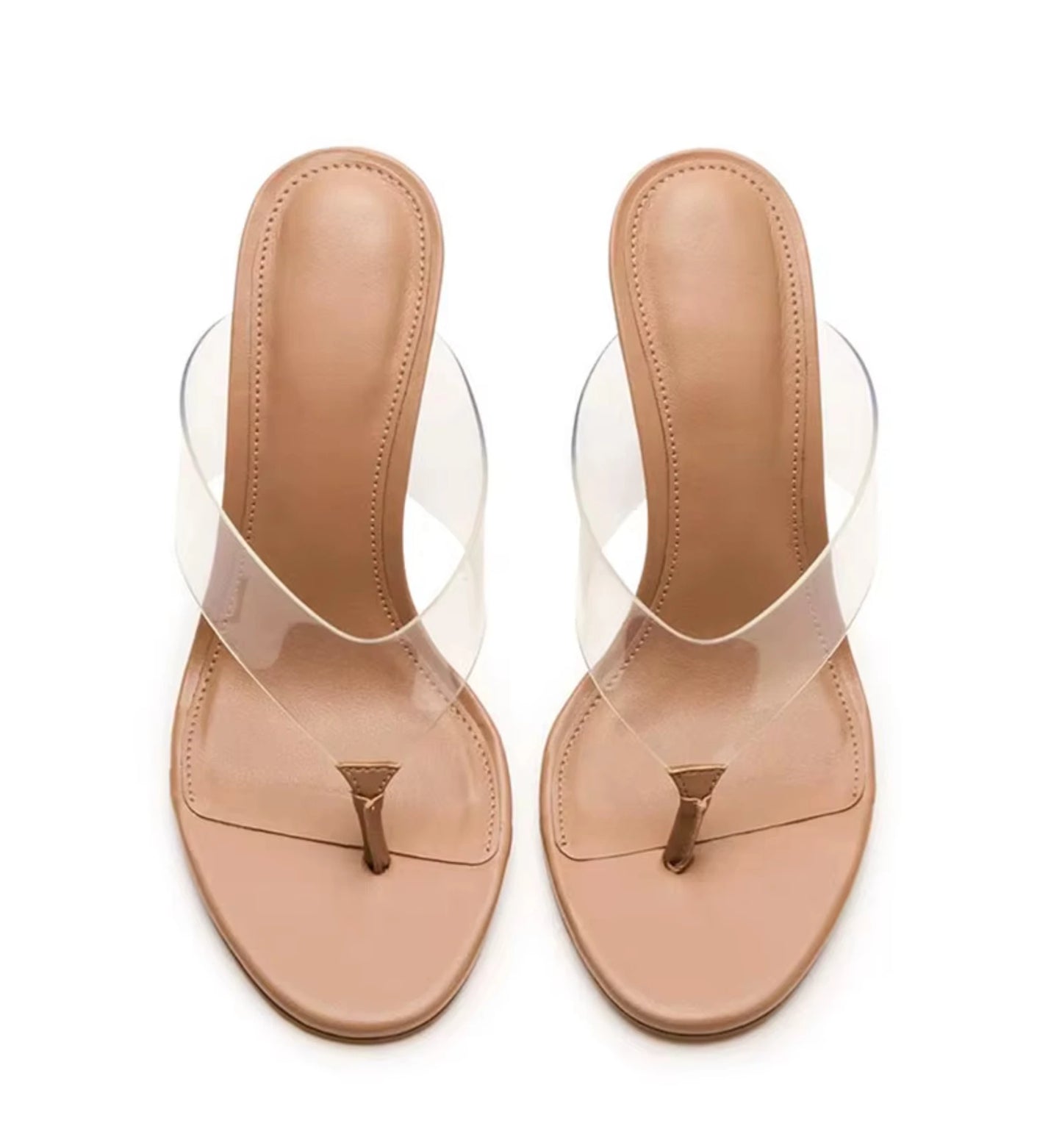 Pair of beige sandals with clear straps on a white background