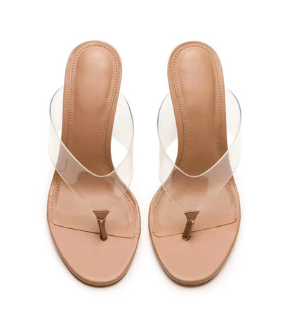 Pair of beige sandals with clear straps on a white background