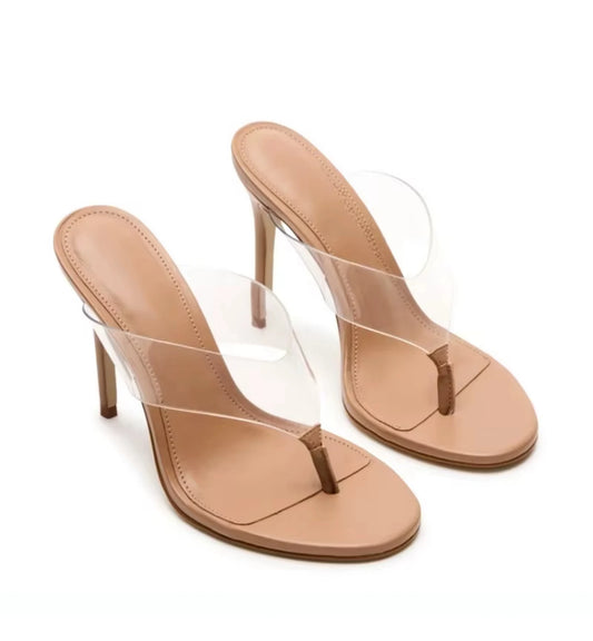 Pair of beige high-heeled sandals with clear straps on a white background