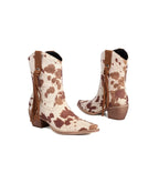 Cowboy boots with brown and white cow print pattern on a white background