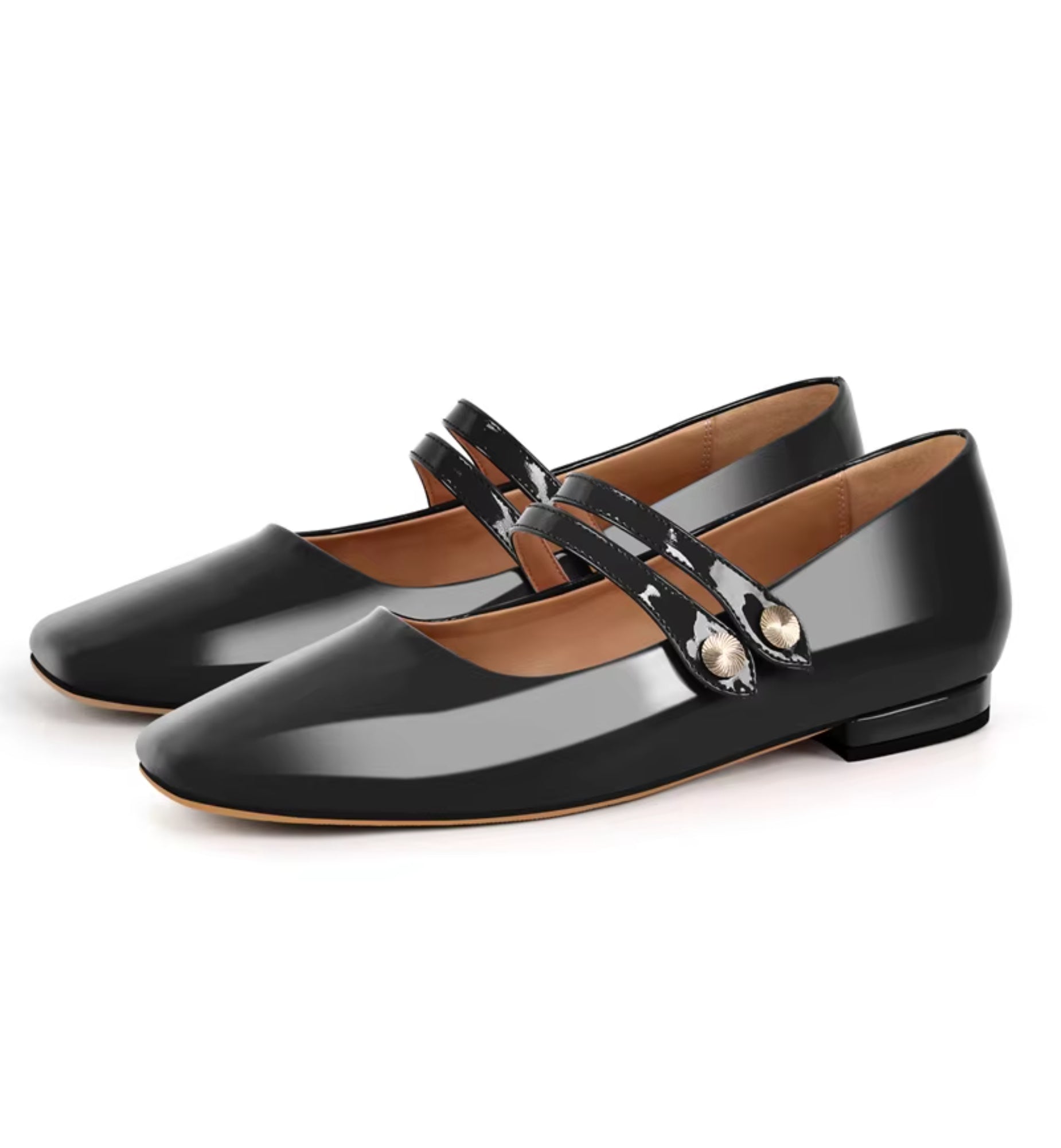 Black patent leather shoes with a strap and decorative buckle on a white background