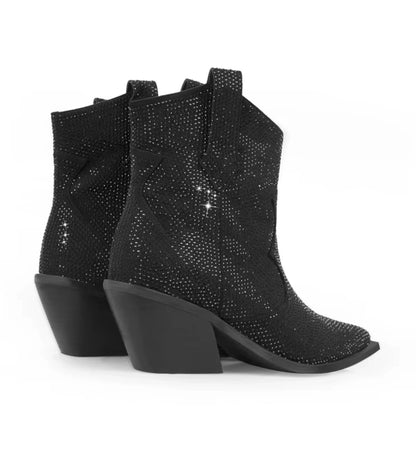 Black studded ankle boots on a white background