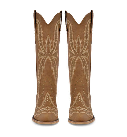 Pair of tan cowboy boots with decorative patterns on a white background