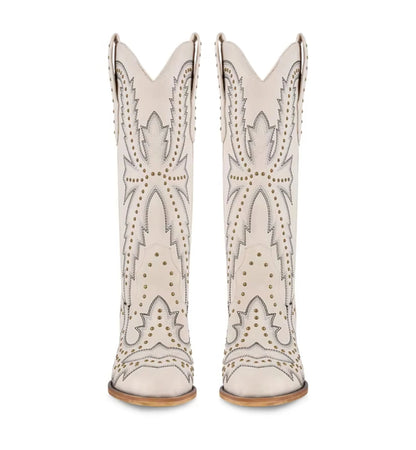 White cowboy boots with decorative patterns and studs on a white background