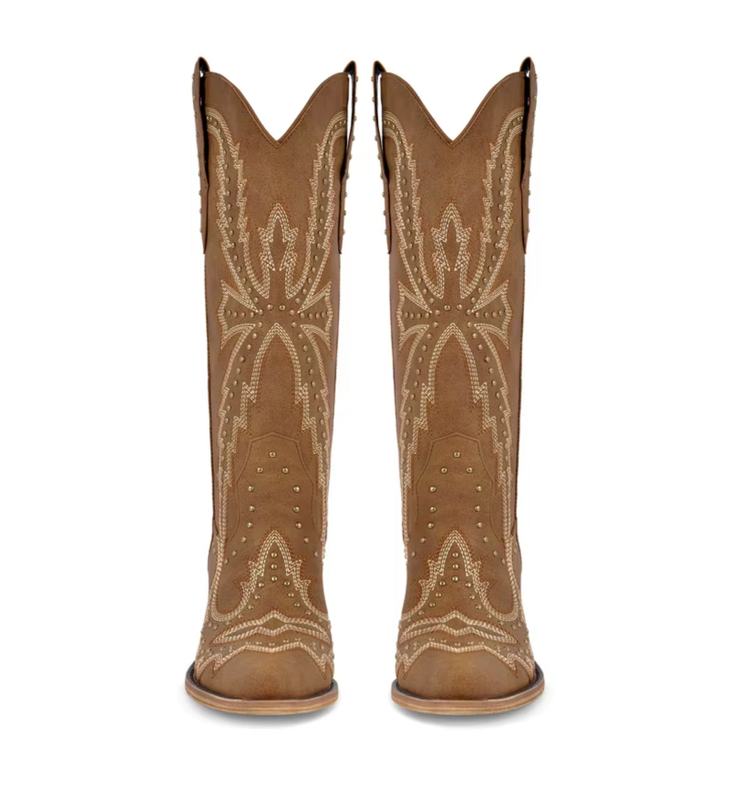 Pair of tan cowboy boots with decorative patterns on a white background