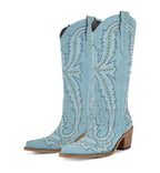 Light blue cowboy boots with intricate designs on a white background