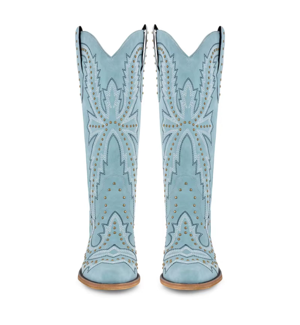 Pair of light blue cowboy boots with decorative patterns on a white background