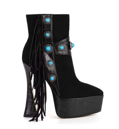 Black high-heeled platform boots with fringe and turquoise embellishments on a white background