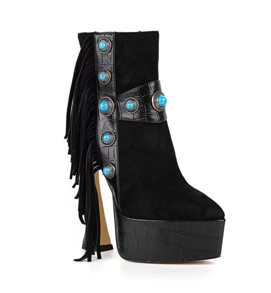 Black platform boot with fringes and turquoise embellishments on a white background