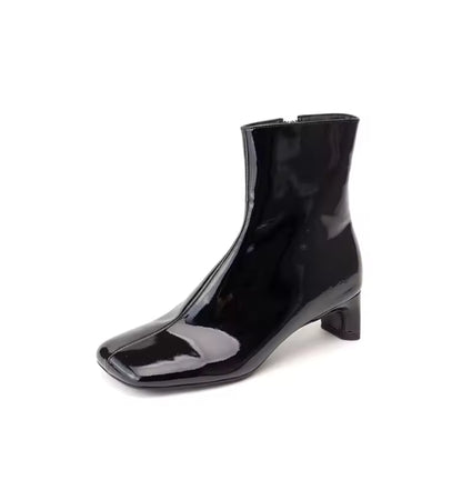 Black patent leather ankle boot on a white background