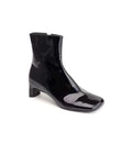 Black patent leather ankle boot on a white background