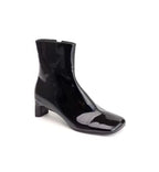 Black patent leather ankle boot on a white background