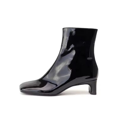 Black patent leather ankle boot on a white background