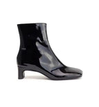 Black patent leather ankle boot on a white background