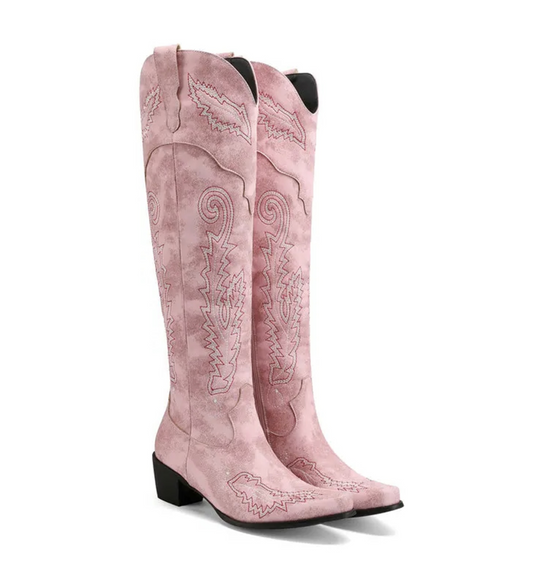 Pink cowboy boots with intricate designs on a white background