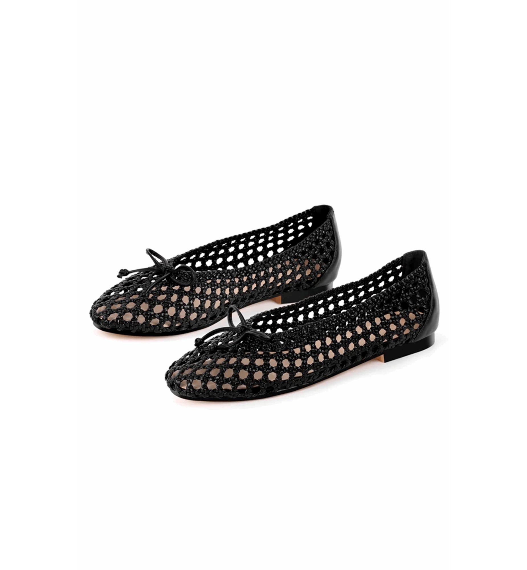 Black perforated ballerina shoes on a white background