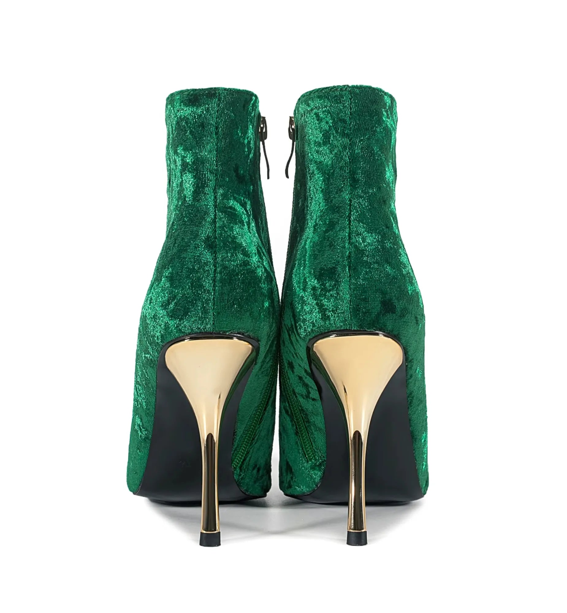 Green velvet high-heeled shoes with gold soles on a white background