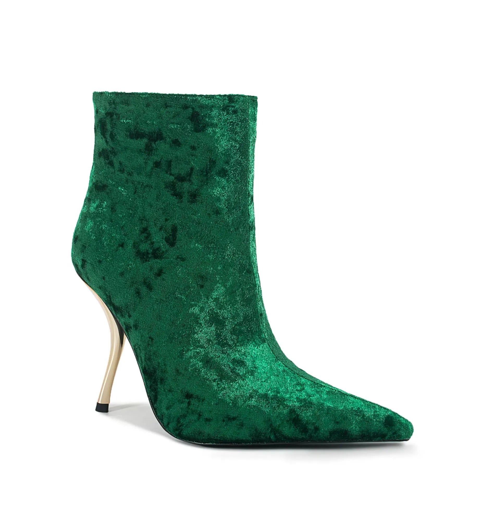 Green velvet ankle boot with a high heel on a white background
